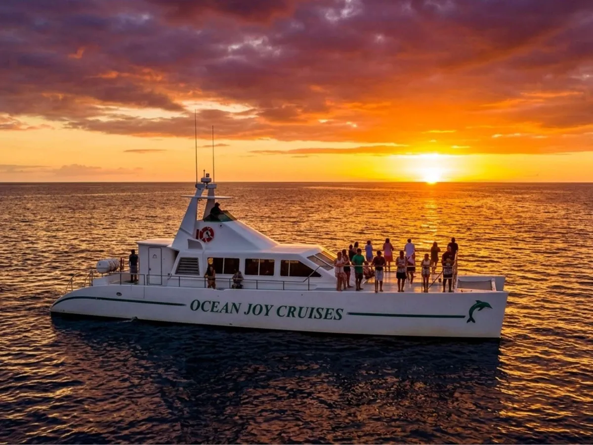 Power catamaran with snorkelers and a Hawaiian buffet on a sunset dinner cruise off Oahu's west coast near Honolulu